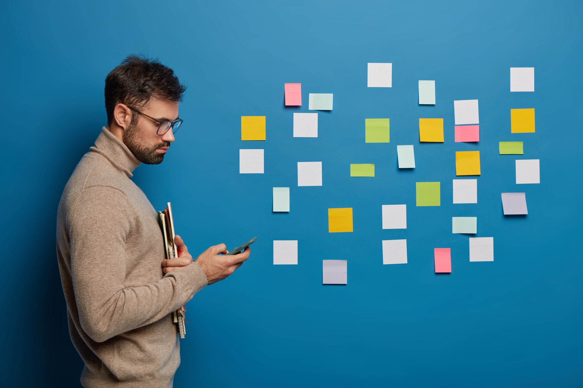 bearded-male-organizing-his-tasks-using-sticky-notes